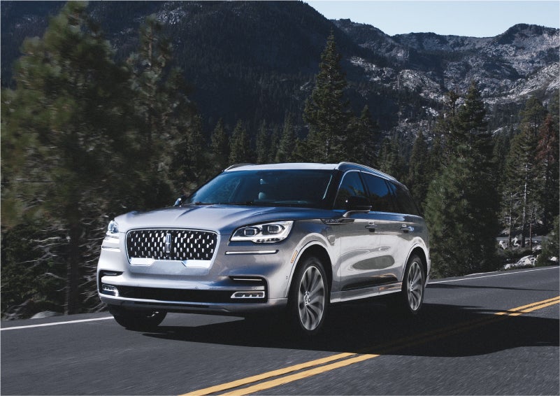 A 2023 Lincoln Aviator® Grand Touring SUV being driven on a winding road to demonstrate the capabilities of all-wheel drive | Varsity Lincoln in Novi MI